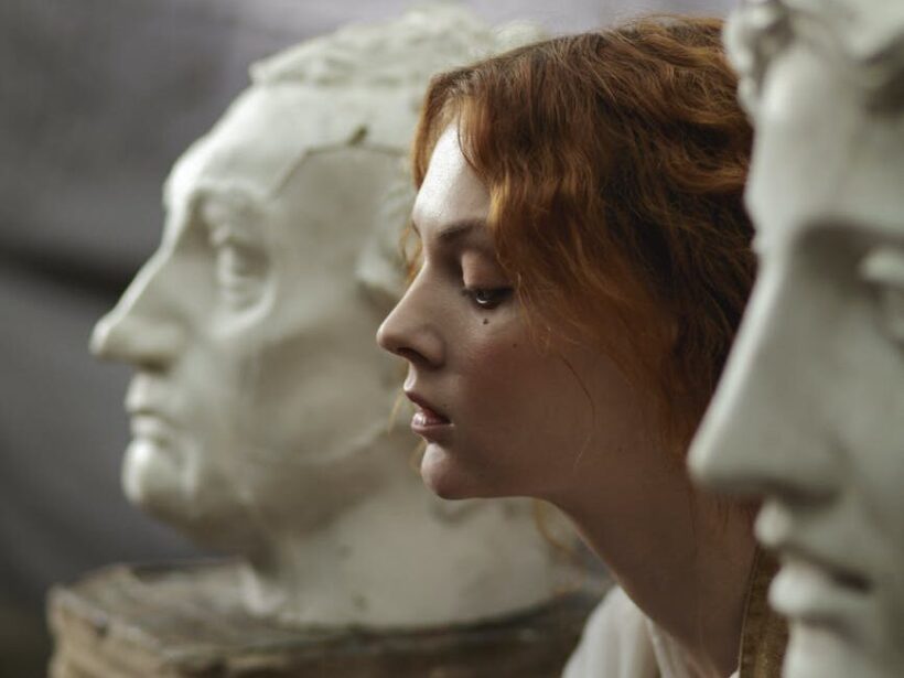 photo of a woman sitting beside statue